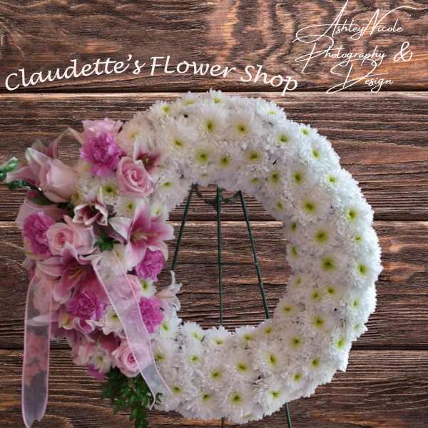 Heart-shaped floral wreath with pink and white flowers on a stand