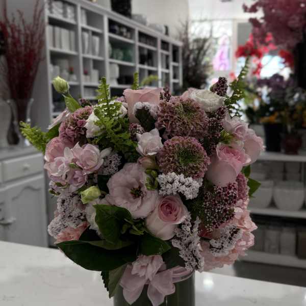 Pink mixed flower bouquet in a dark glass vase