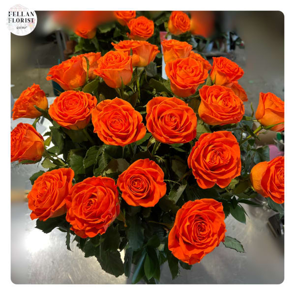Clustered bouquet of vivid orange roses arranged closely together