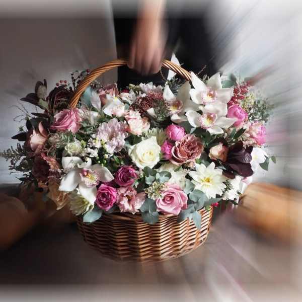 Basket of pink and white mixed flowers with orchids and roses