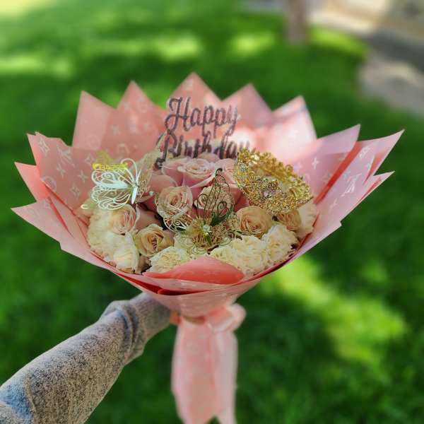 Pink bouquet of roses and carnations with butterfly toppers and a Happy Birthday sign