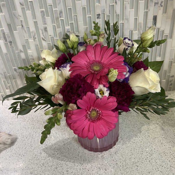 Pink gerbera daisies and white roses in a pink vase