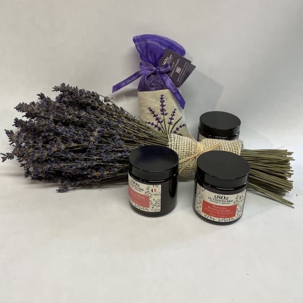 Bundle of dried lavender with three black-lidded jars and a purple sachet