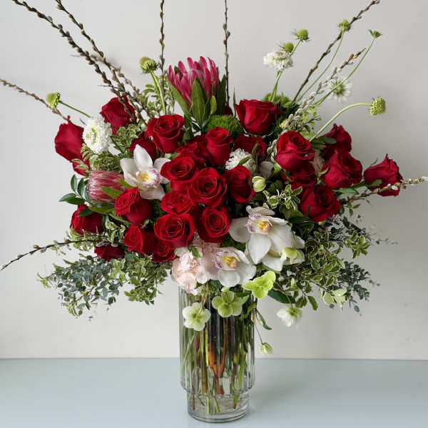 Red roses and white orchids arranged in a clear glass vase