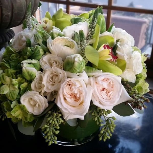 Bouquet of white and pale pink flowers in a green vase