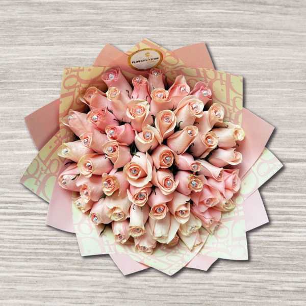 Bouquet of pale pink roses wrapped in patterned paper