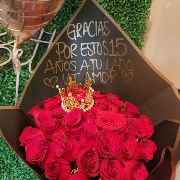Bouquet of red roses with a small decorative crown and a handwritten sign
