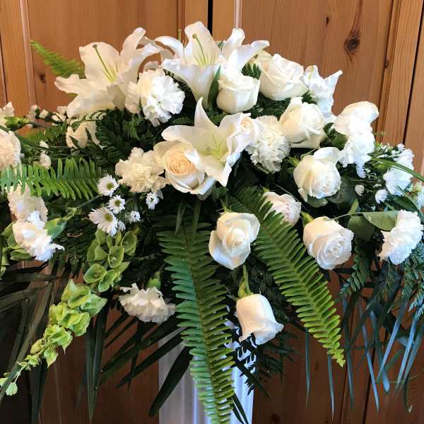 White floral spray with roses and lilies in a standing arrangement