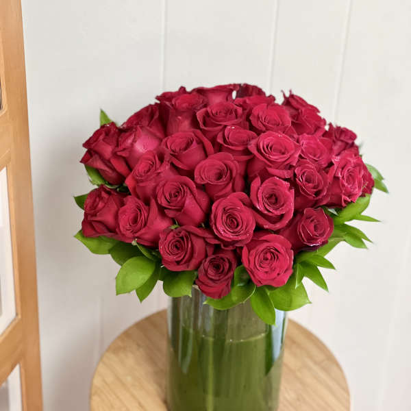 Red rose bouquet in a tall glass vase
