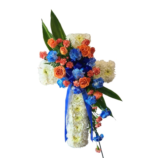 Cross-shaped floral arrangement with white chrysanthemums, orange roses, and blue ribbon