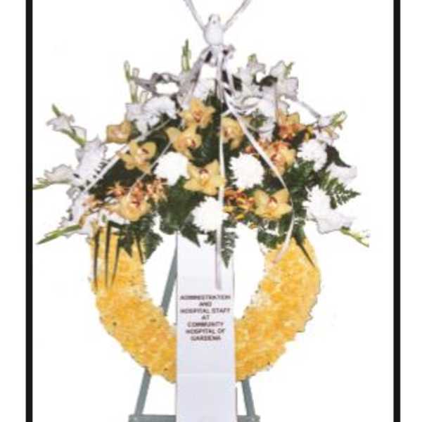 Standing funeral wreath with white and yellow flowers on an easel