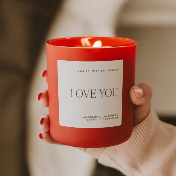 Red candle in a glass jar labeled "LOVE YOU"