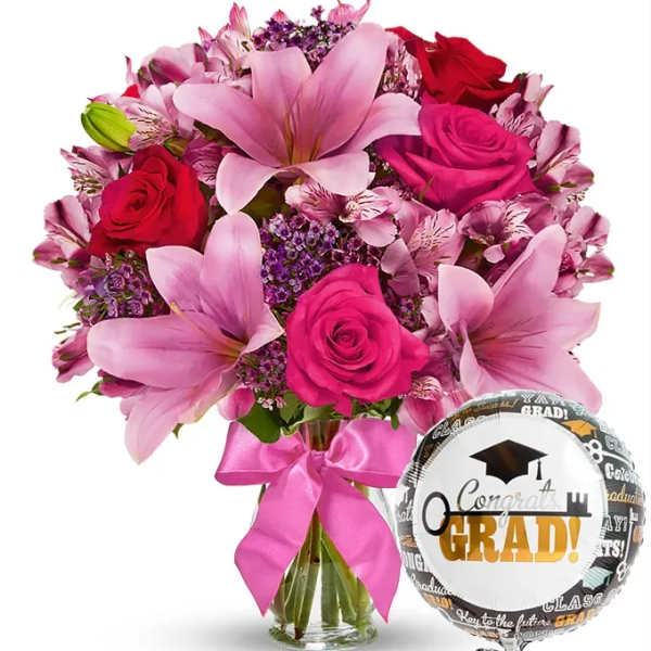 Pink and red bouquet with a graduation balloon and ribbon in a glass vase