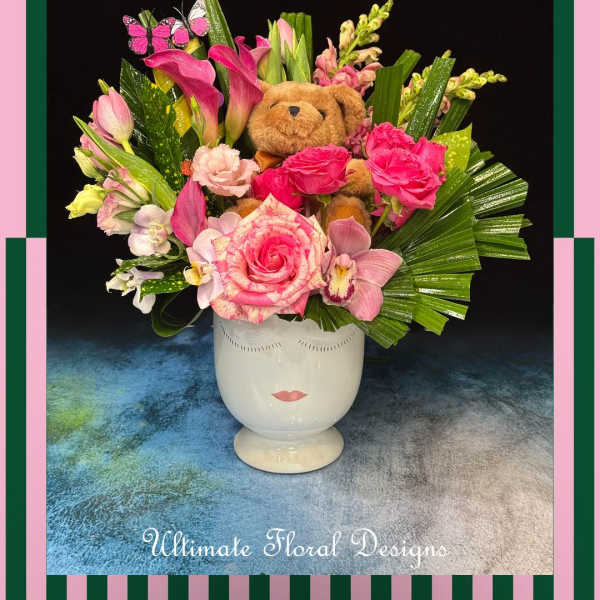 Pink floral arrangement with a teddy bear in a white vase