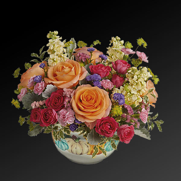 Mixed bouquet of peach and pink roses in a painted ceramic bowl