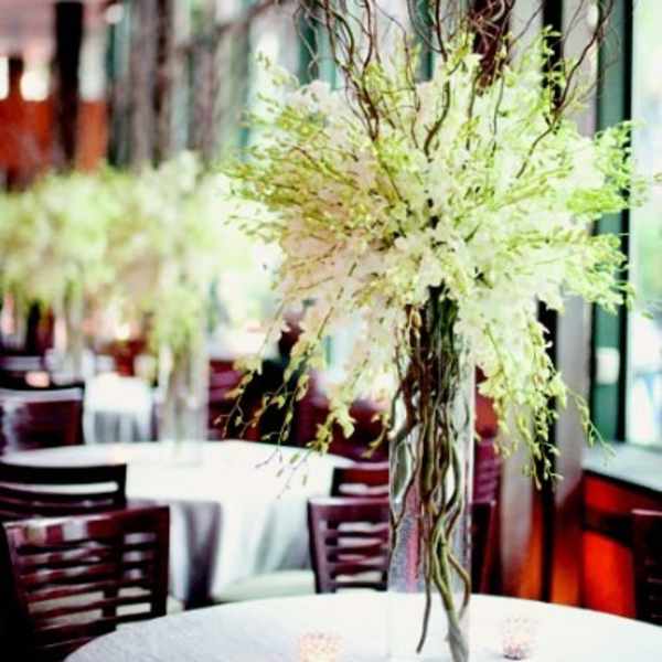 Tall white floral centerpiece in a clear glass vase