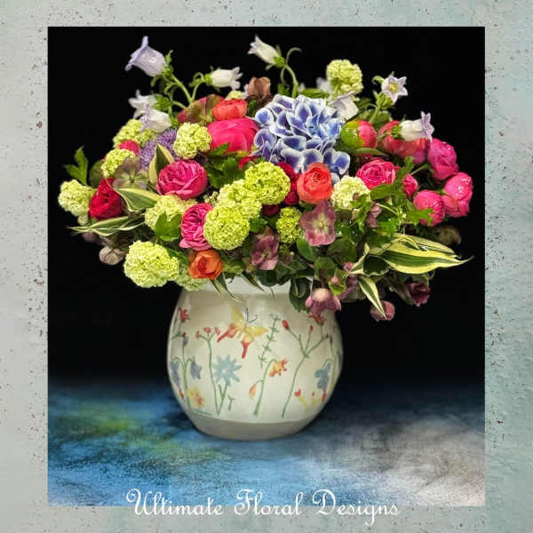 Colorful mixed flower arrangement in a painted ceramic vase