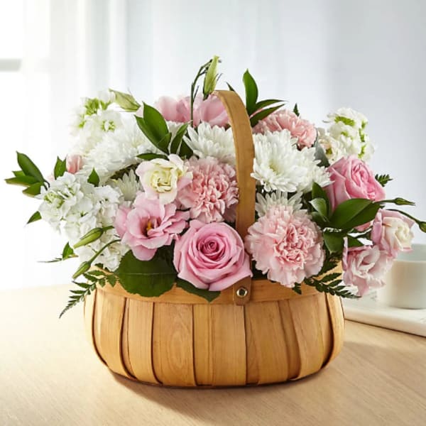 Pink and white flower arrangement in a woven basket