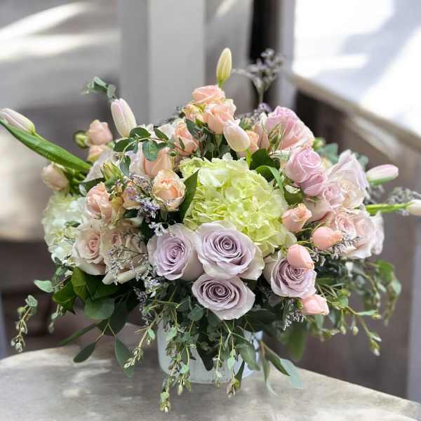 Pastel bouquet of roses, tulips, and hydrangea in a vase