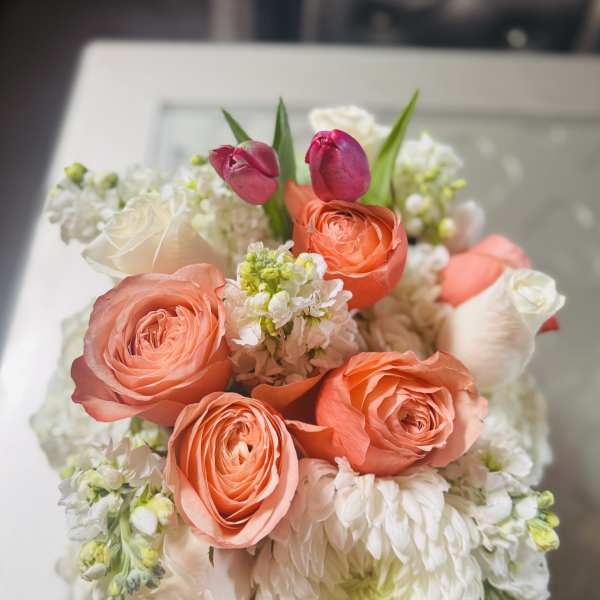Bouquet of coral roses, white blooms, and pink tulips
