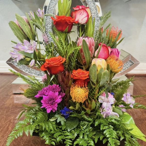 Mixed bouquet with red roses, pink blooms, and orange pincushion flowers