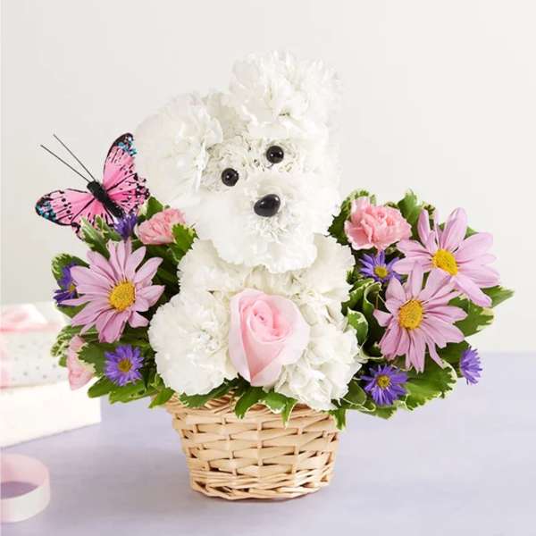 White teddy bear floral arrangement in a wicker basket with pink and purple flowers