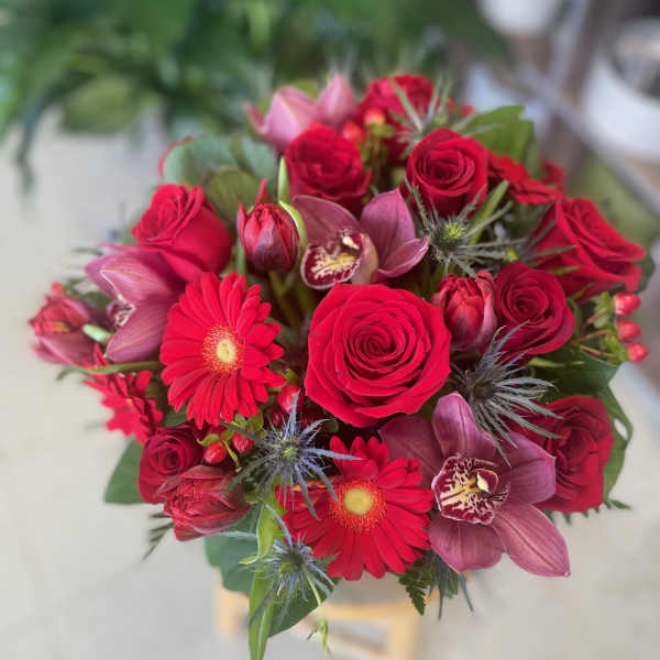 Bouquet of red roses, red gerbera daisies, tulips and mauve orchids