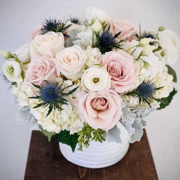 Blush and white rose arrangement in a white vase