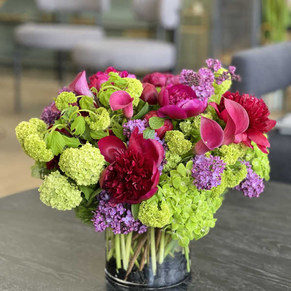 Bright pink and lime green floral arrangement in a glass vase