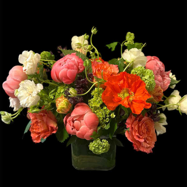Mixed bouquet of pink, white, and orange flowers in a glass vase