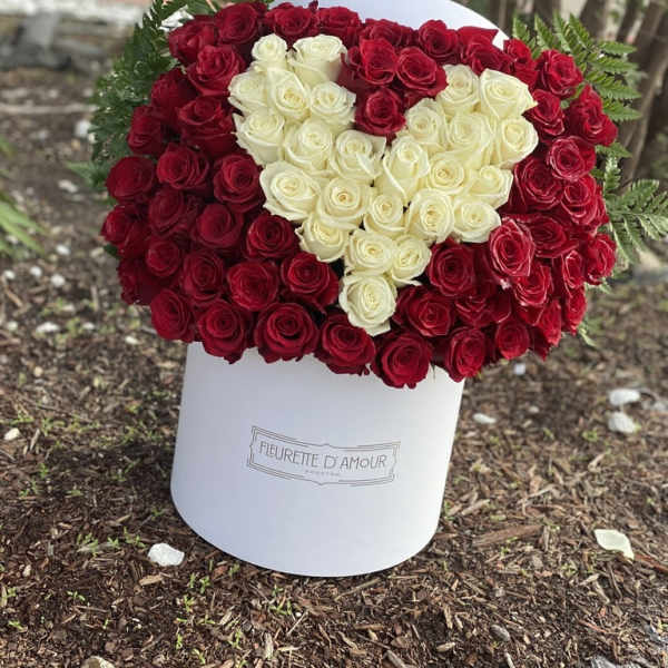 Heart-shaped bouquet of red and white roses in a white box