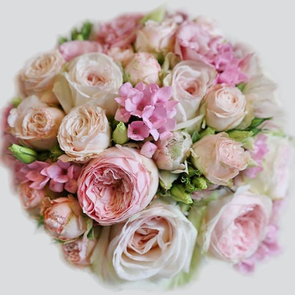 Round bouquet of blush and pink roses with small pink accent flowers