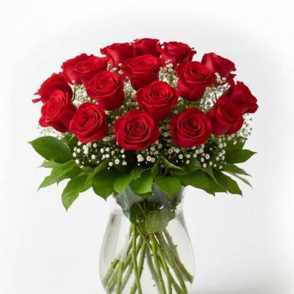 Red roses arranged in a clear glass vase with baby's breath