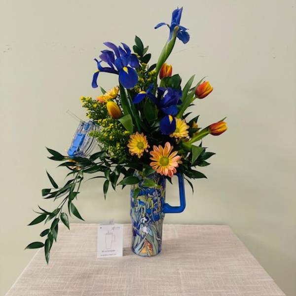 Tall bouquet of blue irises and orange tulips in a patterned vase