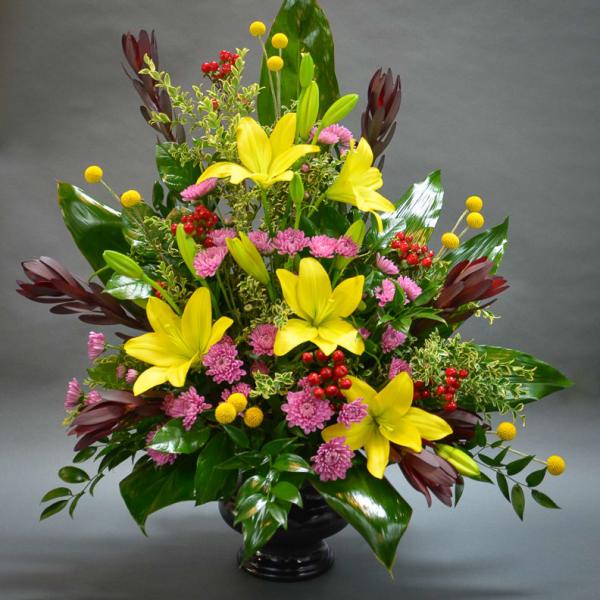 Yellow lilies and pink mums in a black vase