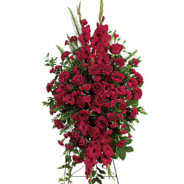 Tall standing spray of red roses and carnations with greenery on a metal easel