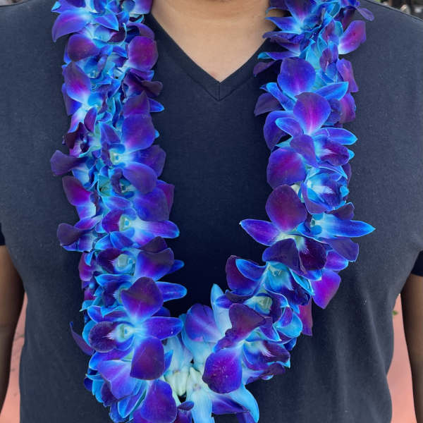 Blue and purple orchid lei worn around a black shirt