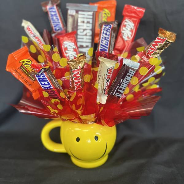 Candy bouquet in a yellow smiley-face mug with assorted chocolate bars