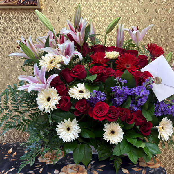 Large bouquet of red roses, lilies, gerbera daisies, and purple flowers
