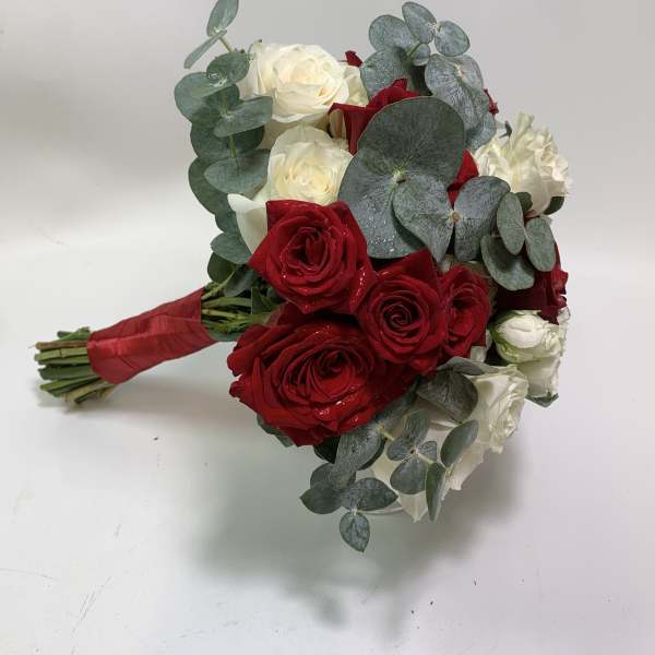 Bouquet of red and white roses with eucalyptus wrapped in red ribbon