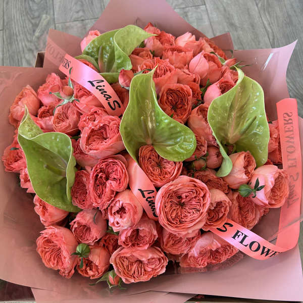 Pink rose bouquet with green anthurium blooms wrapped in pink paper