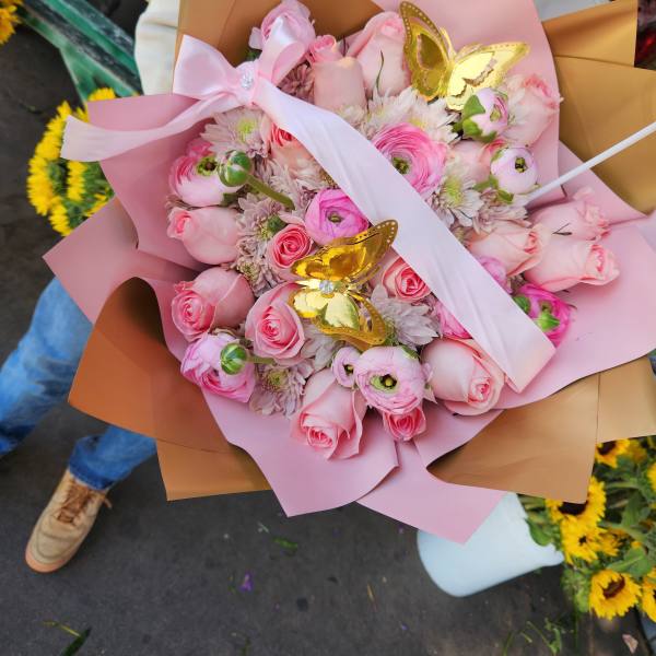 Pink rose and ranunculus bouquet with gold butterfly accents