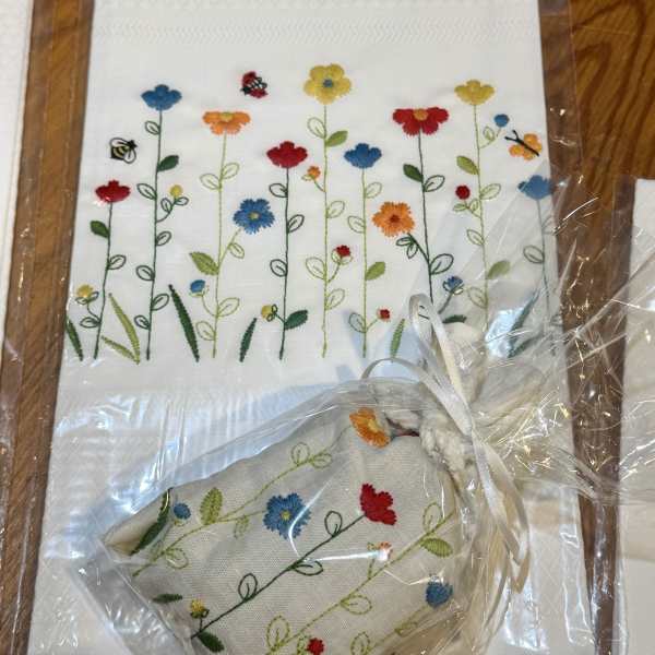 Embroidered floral napkins with a small matching pouch in clear wrapping