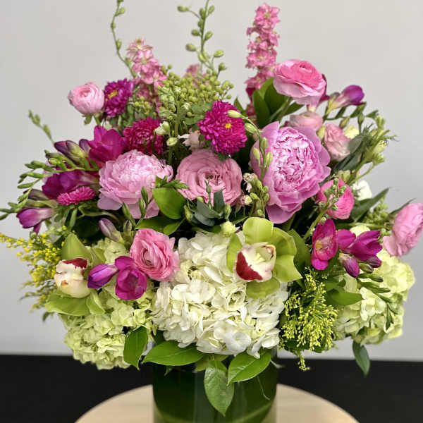 Pink and white mixed bouquet in a green glass vase