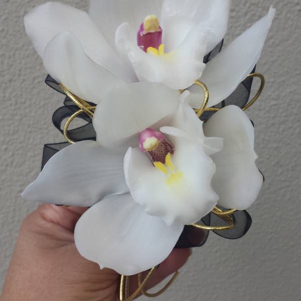 White orchid corsage with black ribbon and gold wire accents