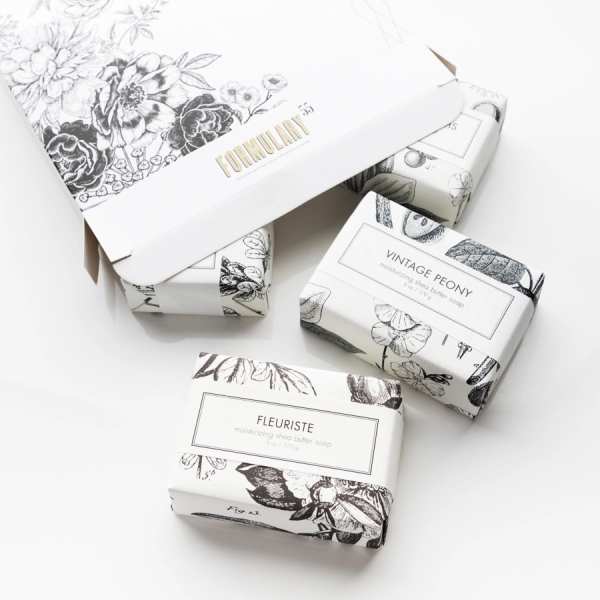 Four floral-patterned soap bars in white boxes on a white background