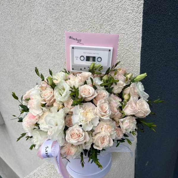 Bouquet of pale pink and white roses in a white hat box with a pink card