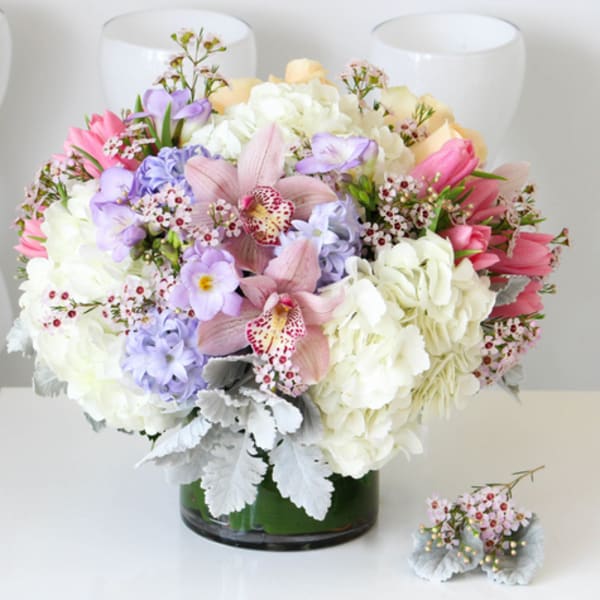 Mixed pastel bouquet in a glass vase with a matching boutonniere