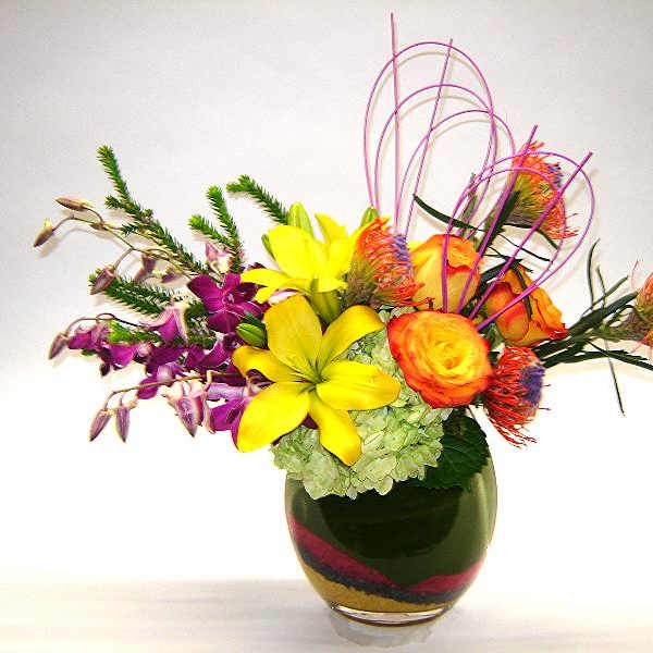 Bright mixed bouquet in a glass vase with yellow and orange blooms