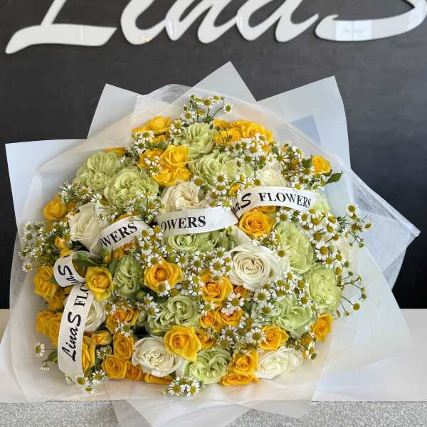 Bouquet of yellow, white, and pale green roses with small daisies